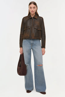 Dark brown leather jacket with collared neckline, front zip closure, and dual chest patch pockets.