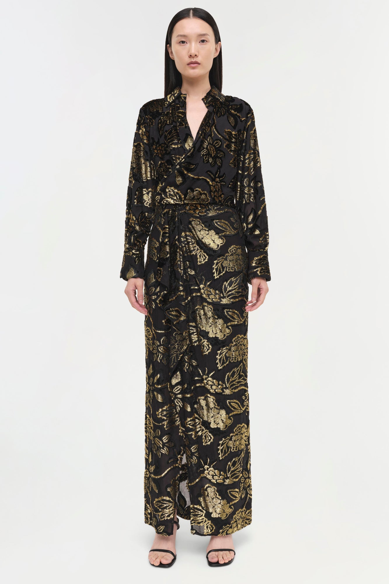 Black silk gown with gold floral print, long sleeves, wrap front, and floor-length skirt.