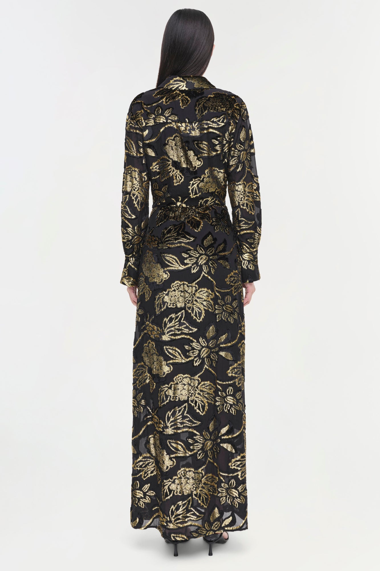 Black long-sleeve floor-length gown with gold floral print and metallic finish throughout.