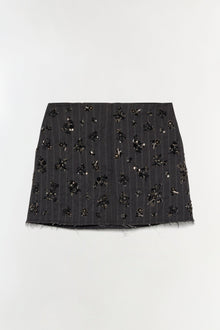 Black mini skirt with all-over beaded and sequin embellishments, frayed hem, vertical pinstripe pattern.