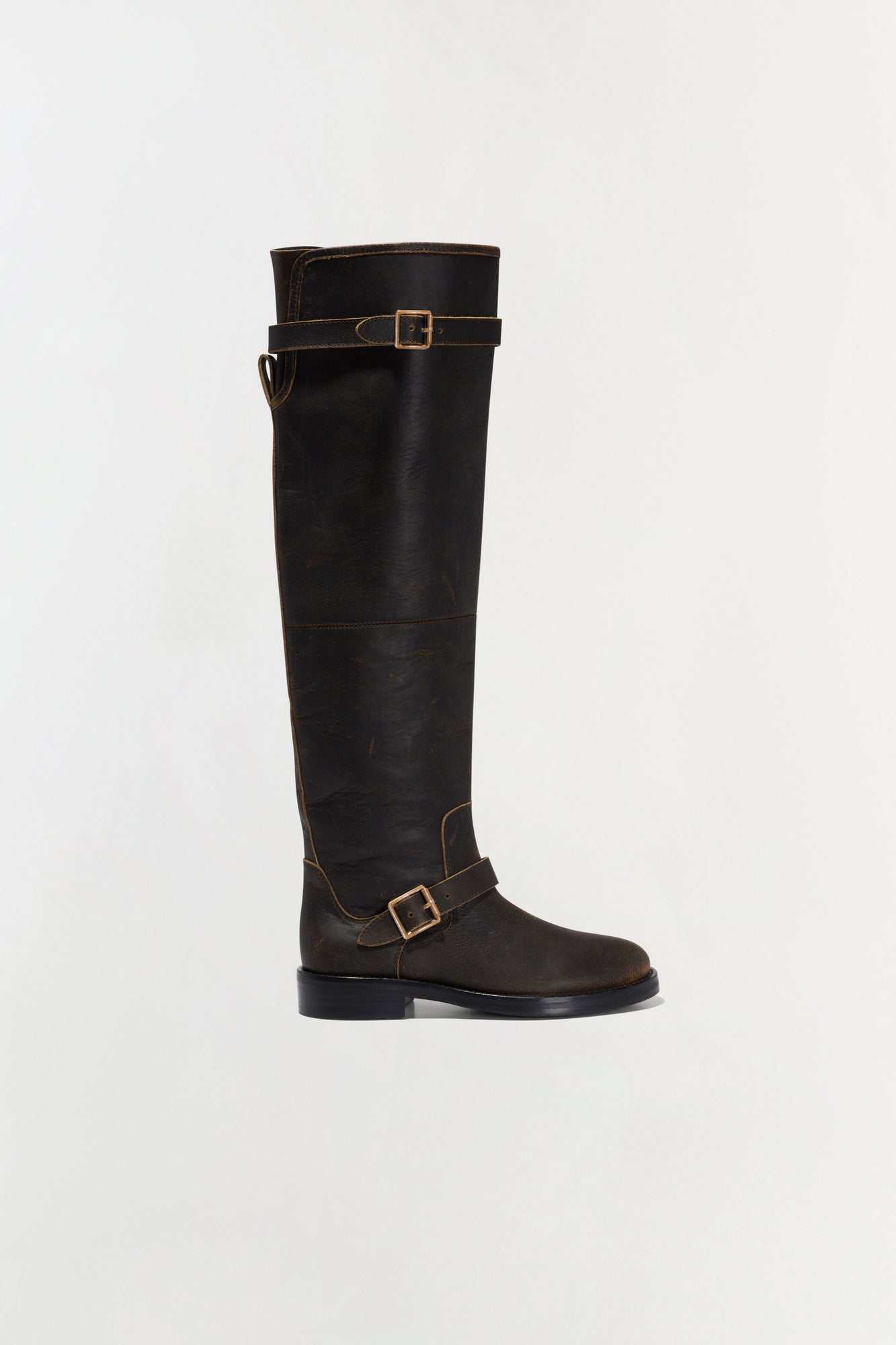 Black leather over-the-knee boot with gold buckle straps and flat sole.