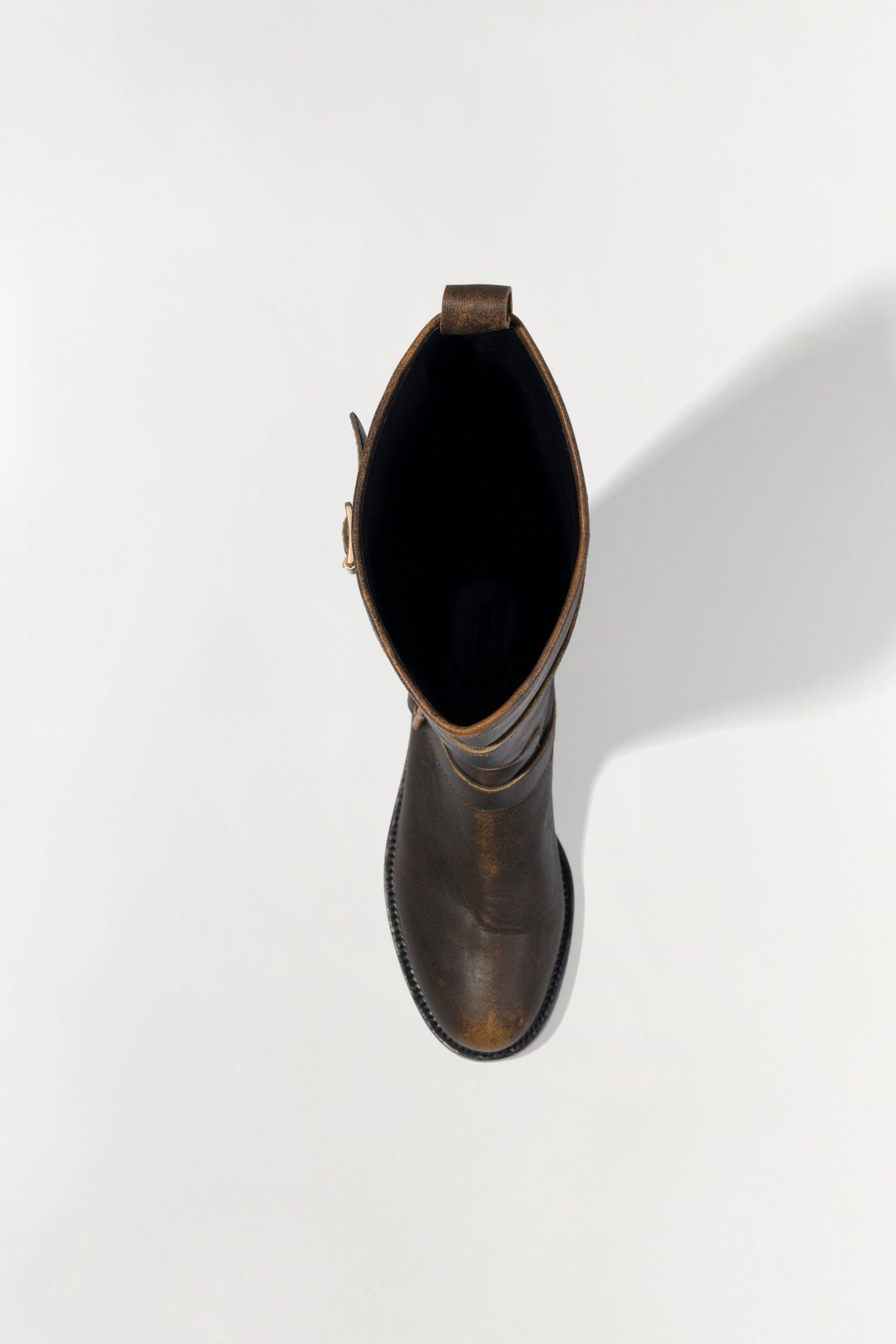 Brown leather moto boot with buckle strap, shown from above with open top view.