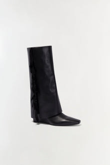 Black leather boot with fringe trim along the back shaft and a pointed toe.