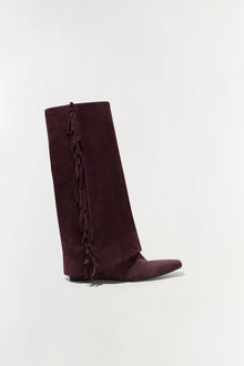 Burgundy suede knee-high boot with fringe trim down the side seam, shown in profile view.