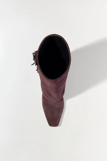 Burgundy suede boot with fringe tassel detail on the side, shown from top view.