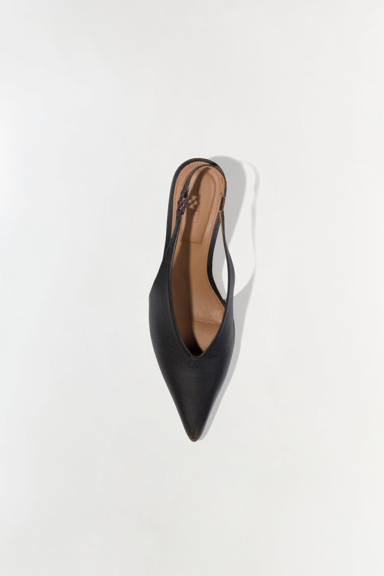 Black slingback kitten heel with pointed toe and tan leather insole, shown from above.