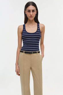 Woman wearing beige Ansel trousers with a black belt and navy striped tank top.