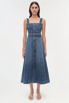 Blue denim sleeveless dress with square neckline, button front, and belted waist on a model.