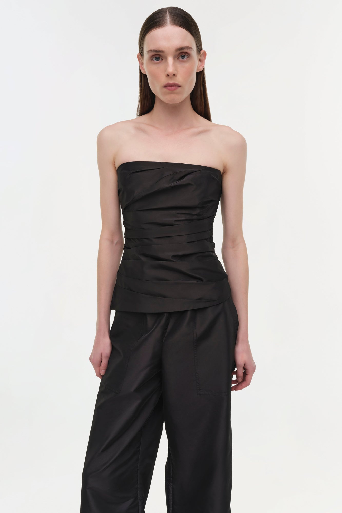 Woman wearing black taffeta pull-on pants with a strapless black top.