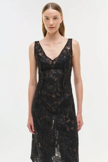 Black sequined lace midi dress with V-neckline and sleeveless design worn by model.