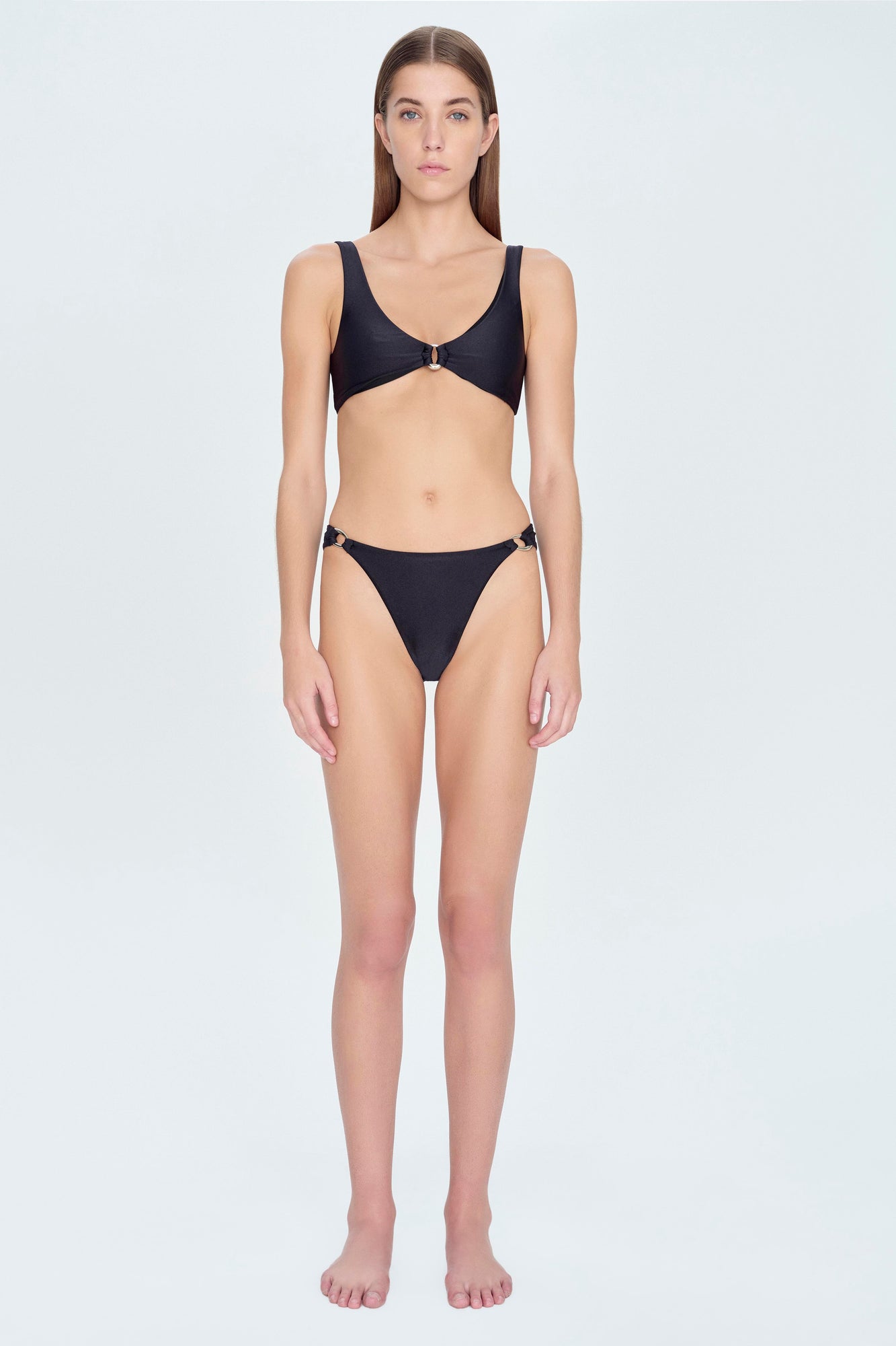 Black bikini bottom with side buckle details on a model wearing matching bikini top.