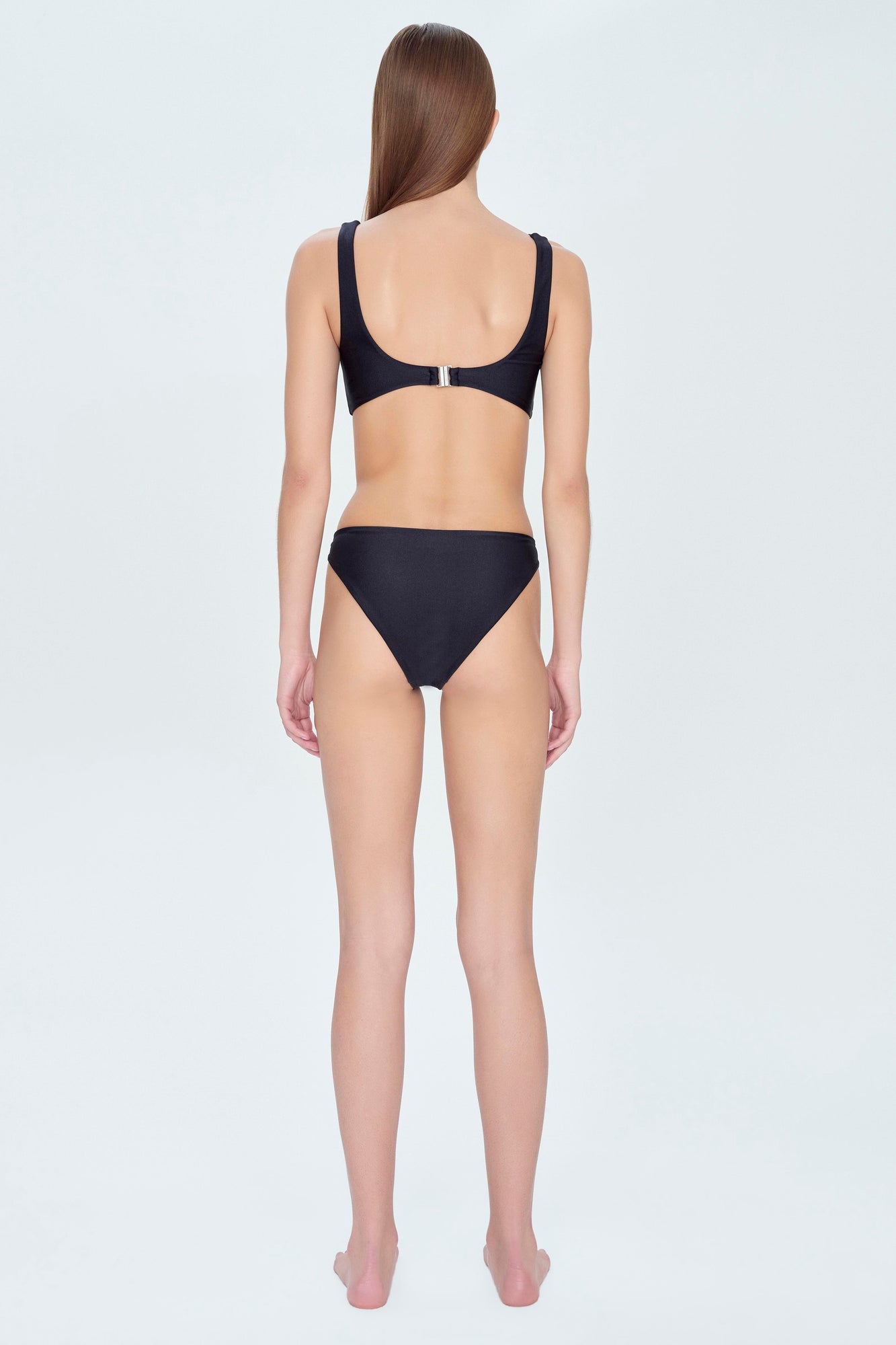 Black bikini bottom with high-cut legs and moderate coverage, shown on model from back view.