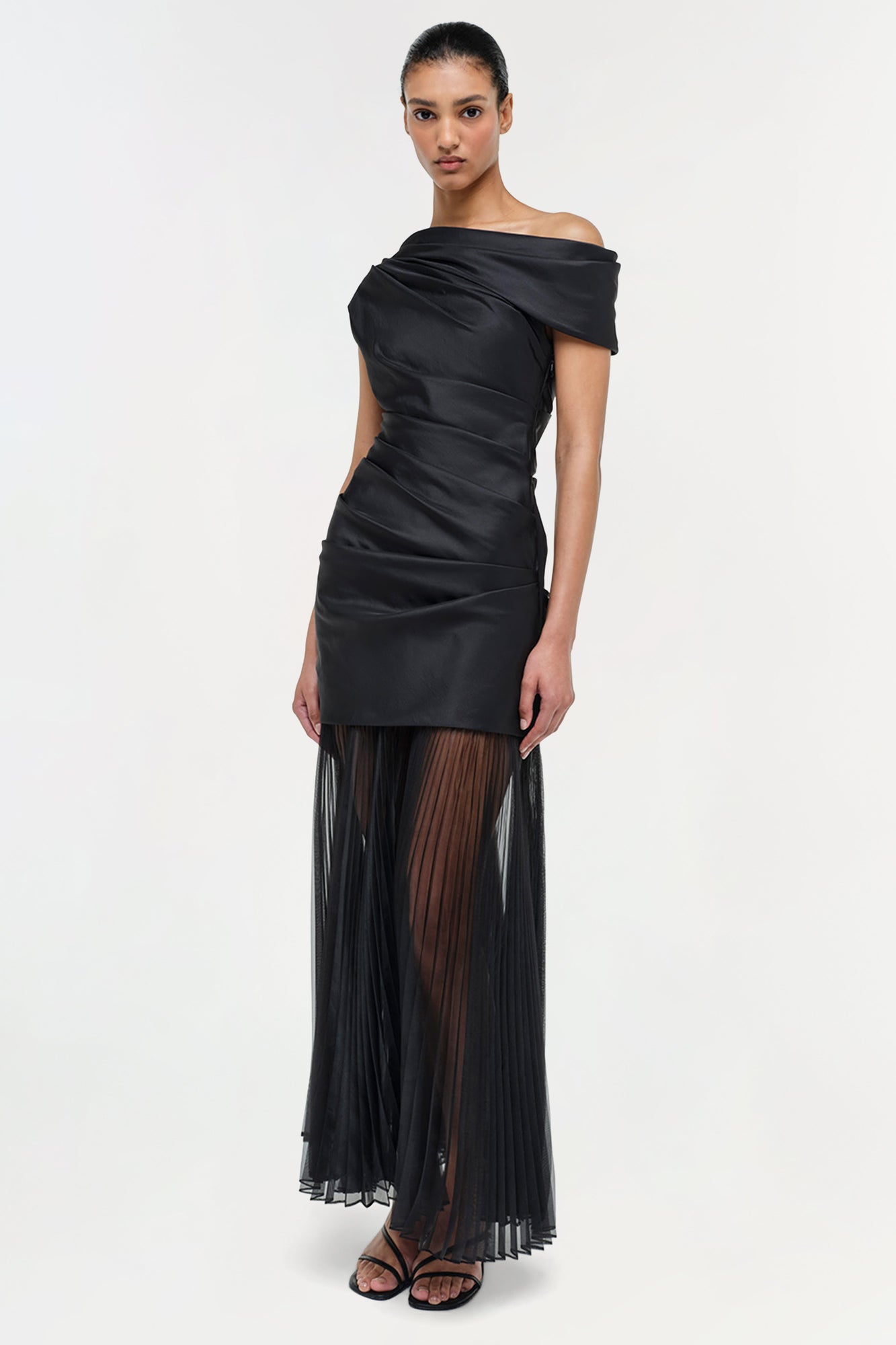 Black off-shoulder midi dress with ruched bodice and pleated sheer skirt.