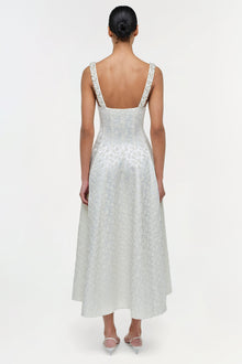 Woman wearing white jacquard midi dress with square neckline and wide straps, shown from back view.