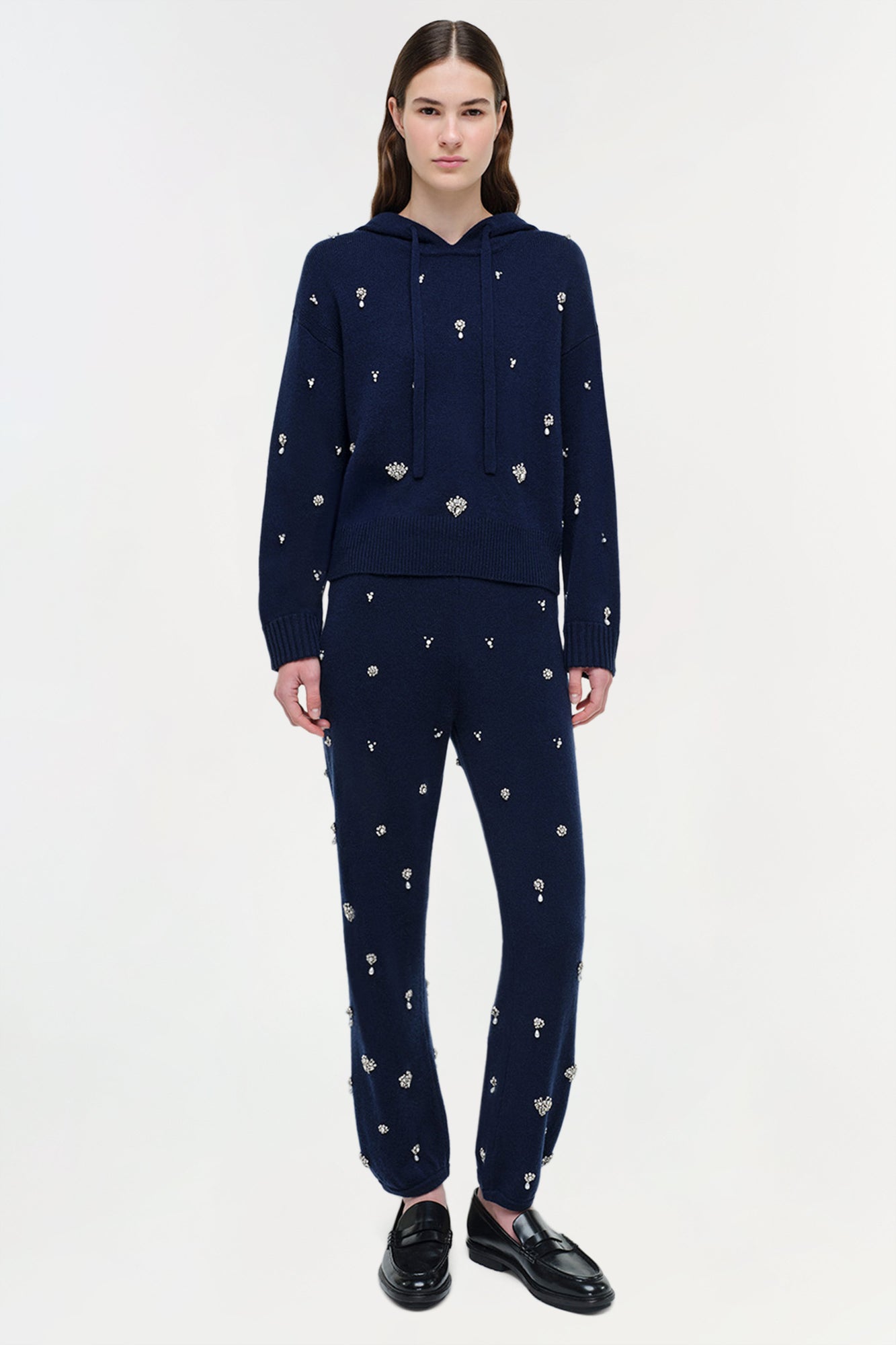 Navy cashmere cropped hoodie with scattered crystal embellishments worn with matching embellished pants.