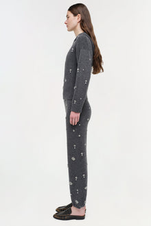 Woman wearing charcoal cashmere jogger set with scattered crystal embellishments, shown in side profile.
