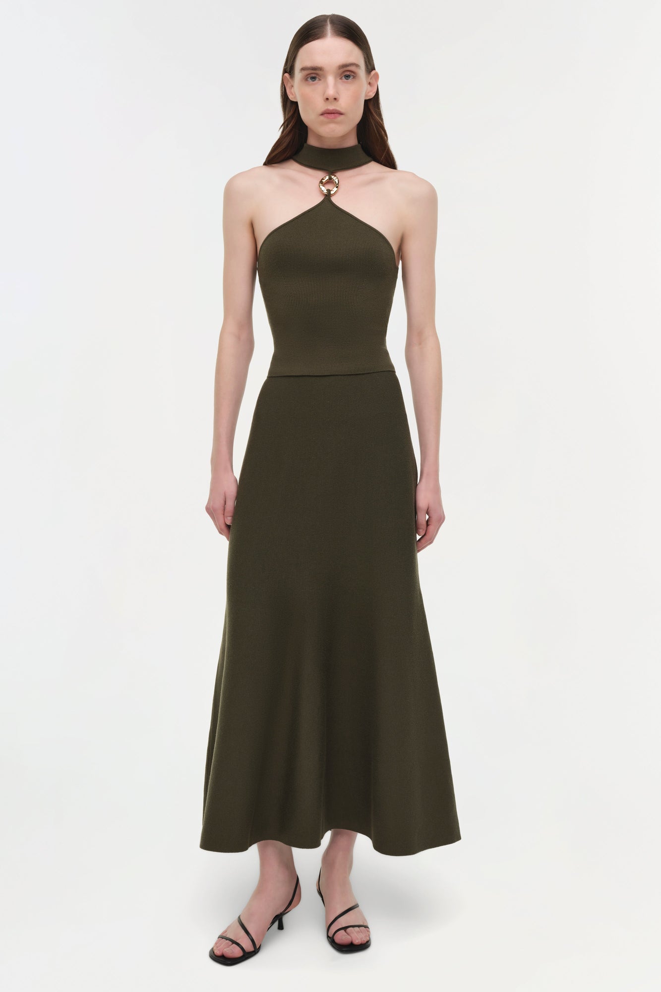 Olive wool midi skirt with A-line silhouette and high waistband on model wearing black halter top.