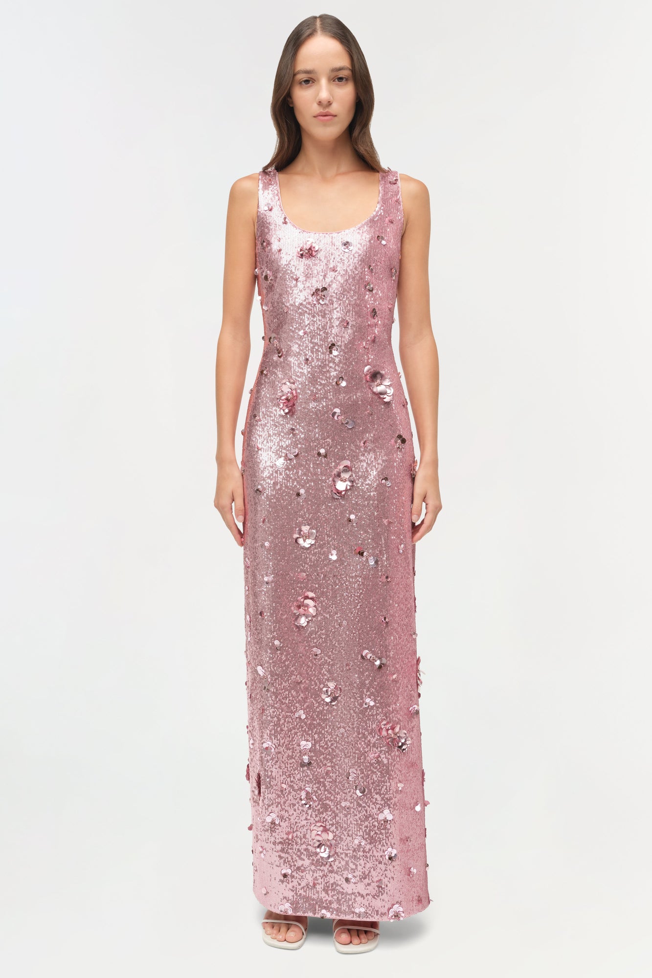 Sleeveless floor-length gown in pink sequins with scattered embellishments, scoop neckline, fitted silhouette.