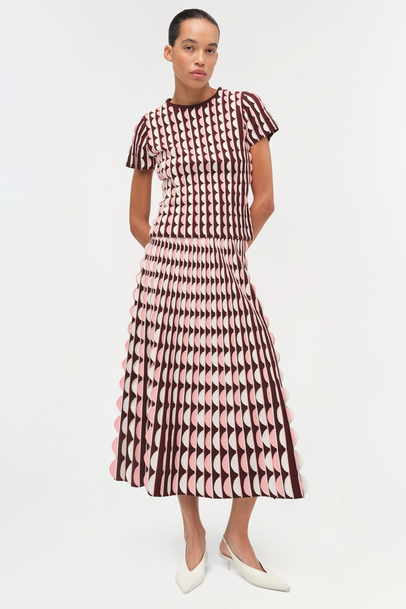 Burgundy and white knit midi skirt with scalloped edge detail and geometric pattern, shown with matching short-sleeve top.