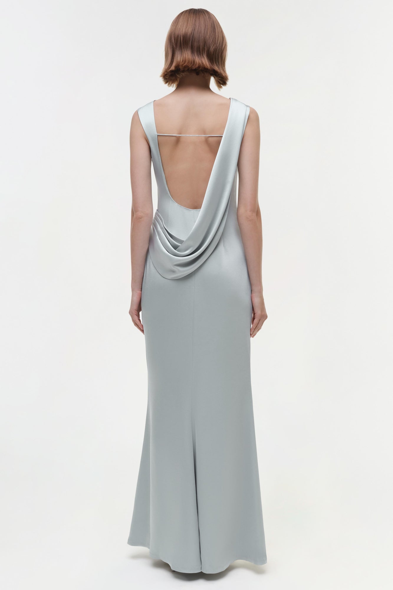 Light gray sleeveless floor-length gown with draped open back detail, shown from rear view.