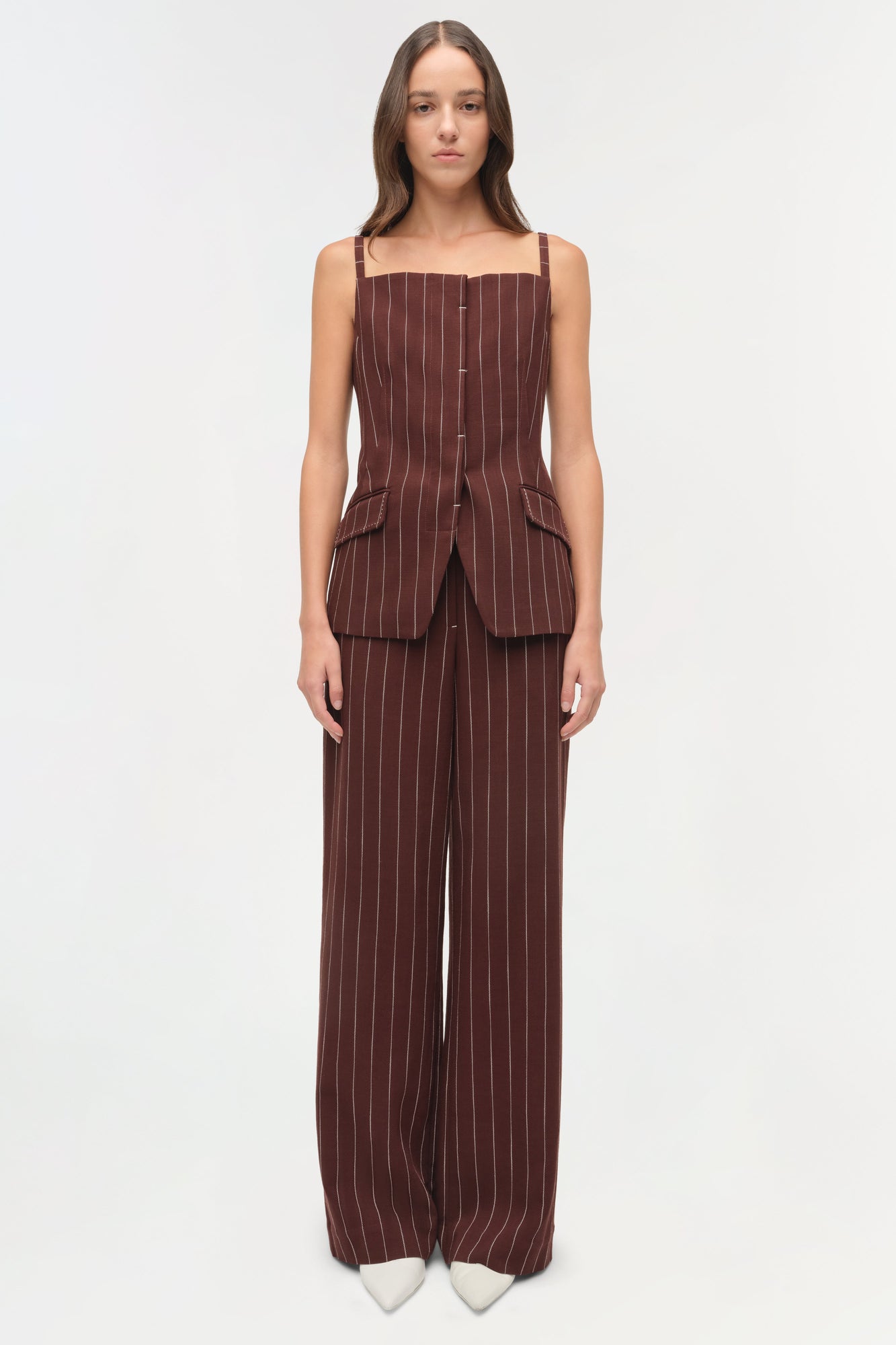 Burgundy pinstriped wide-leg pants with matching sleeveless vest top, worn with white pointed-toe shoes.