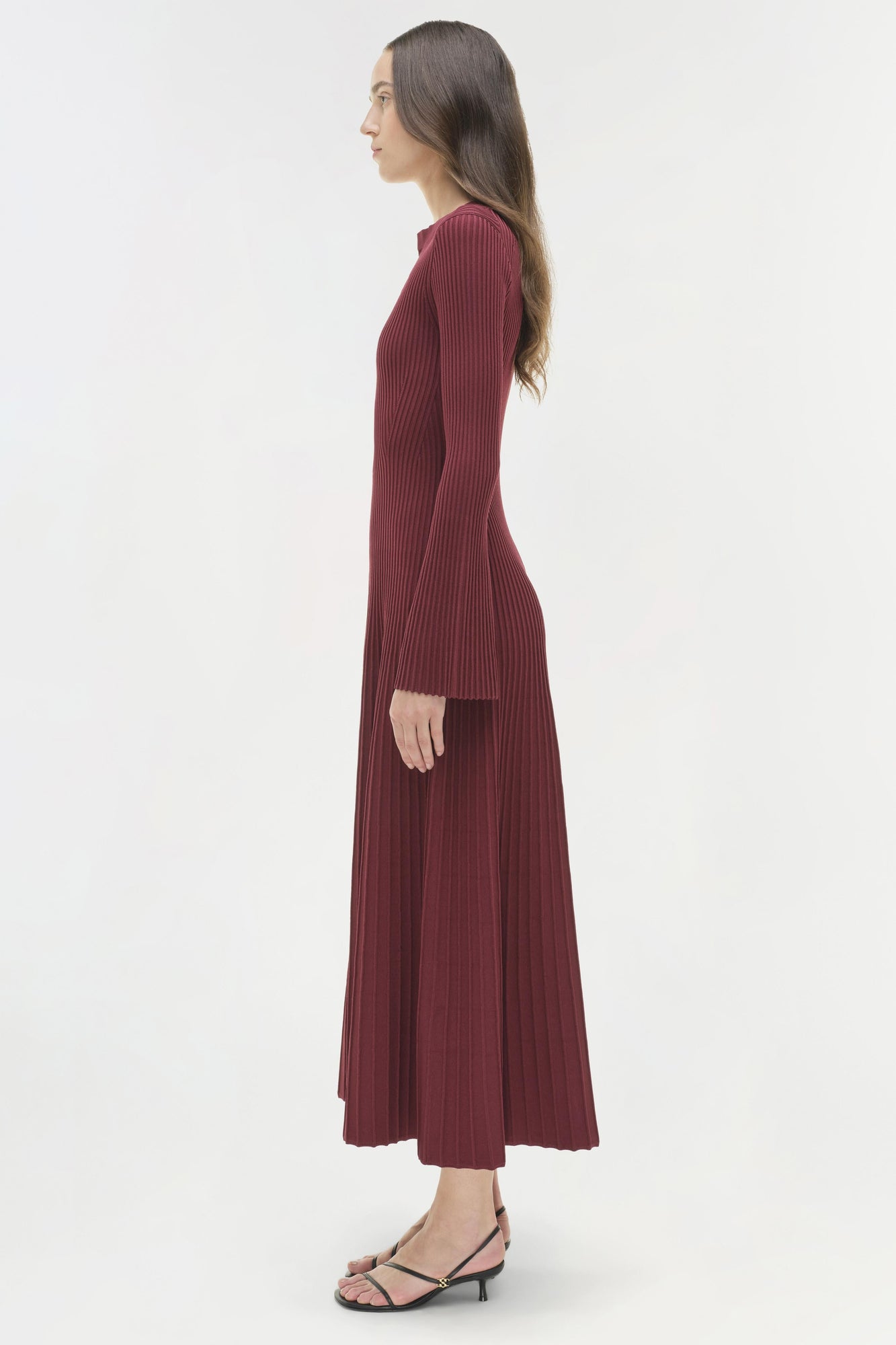 Burgundy ribbed knit midi dress with long sleeves on model shown from side profile.