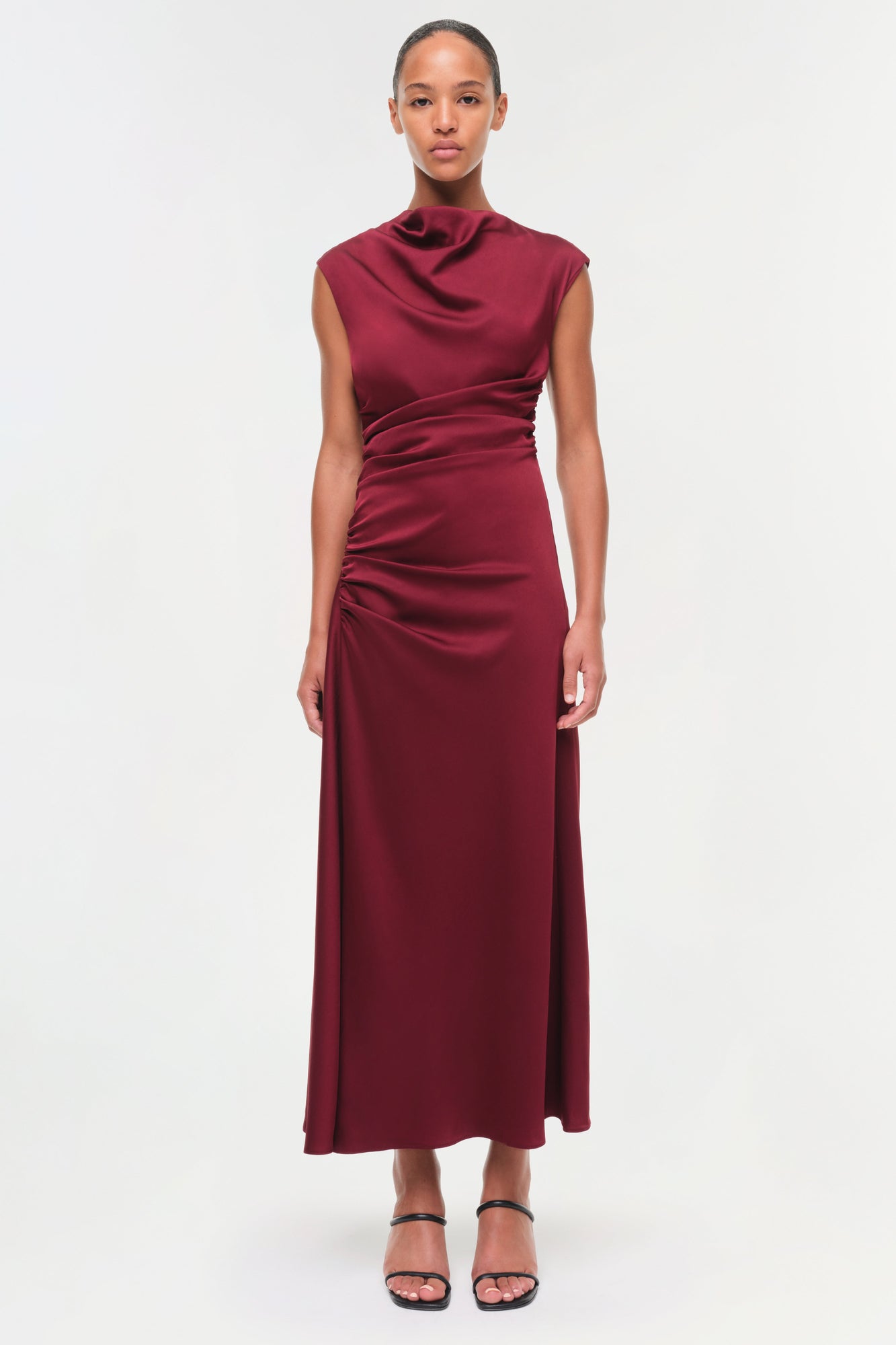 Burgundy satin midi dress with draped neckline, sleeveless design, and ruched side detailing.
