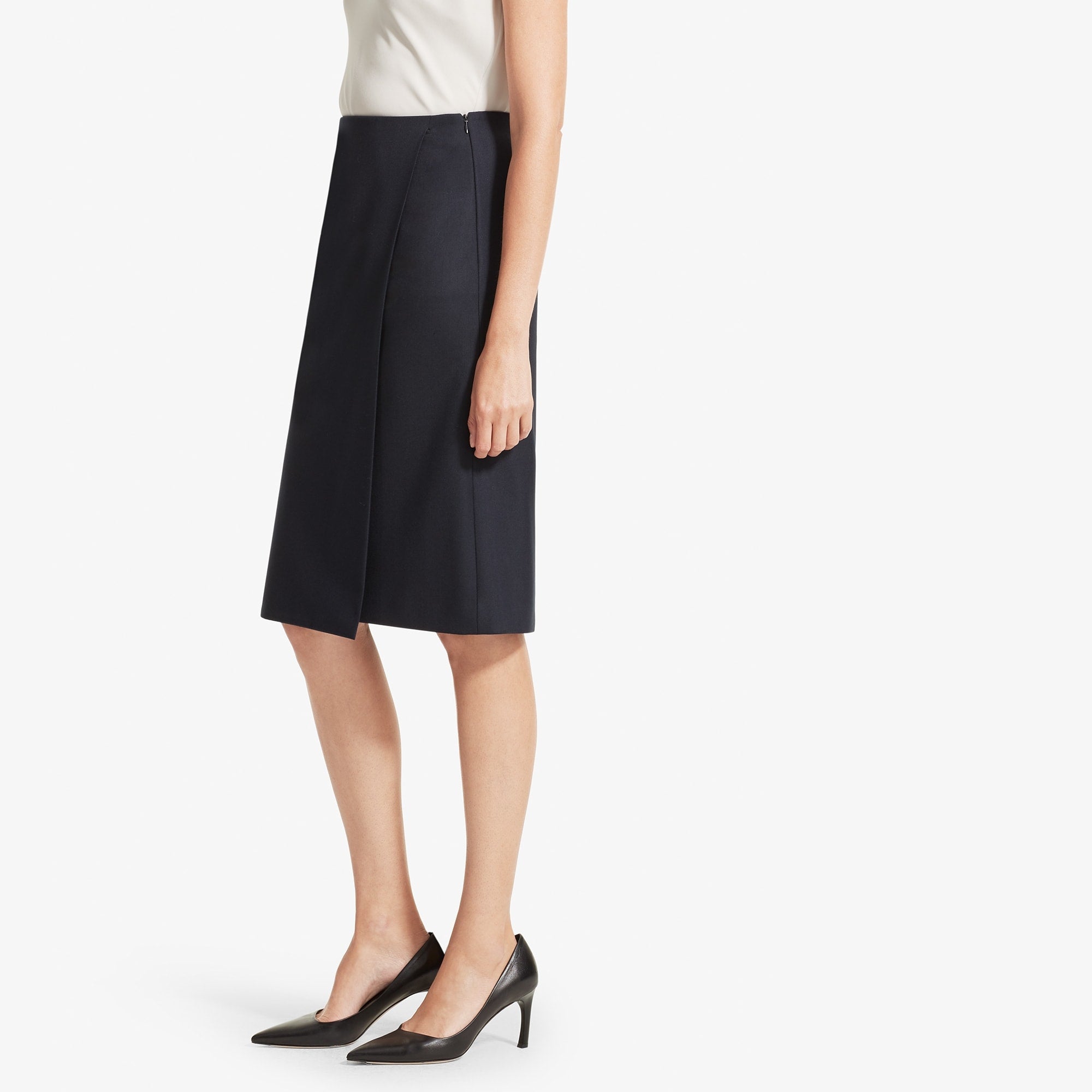 Side image of a woman standing wearing the Logan skirt sharkskin in Ink | Exclude