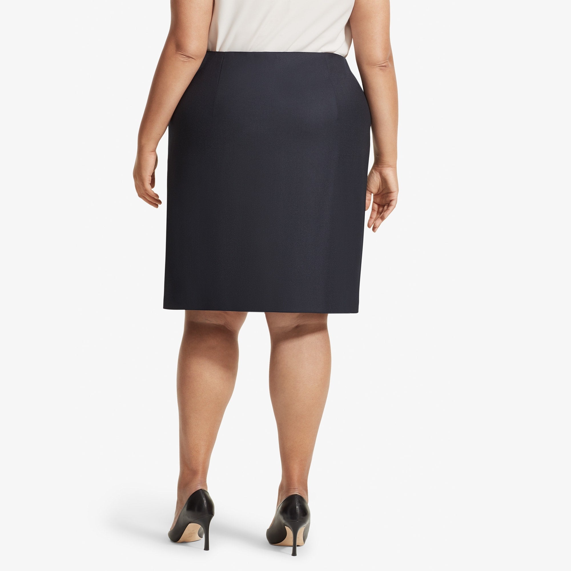 Back image of a woman standing wearing the Logan skirt sharkskin in Ink