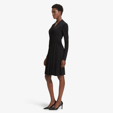 Side image of a woman standing wearing the Morgan dress in Black