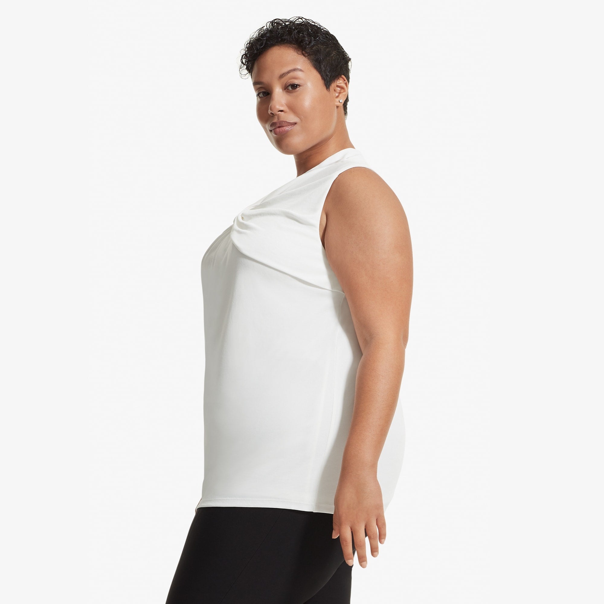 Side image of a woman standing wearing the Walters top knit crepe in Ivory | Exclude