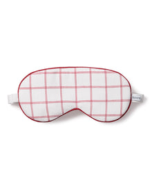 The Adults Twill Sleep Mask in Garnet Tattersall features a red grid pattern with a small “PETITE” label and an elastic strap for a comfortable fit.