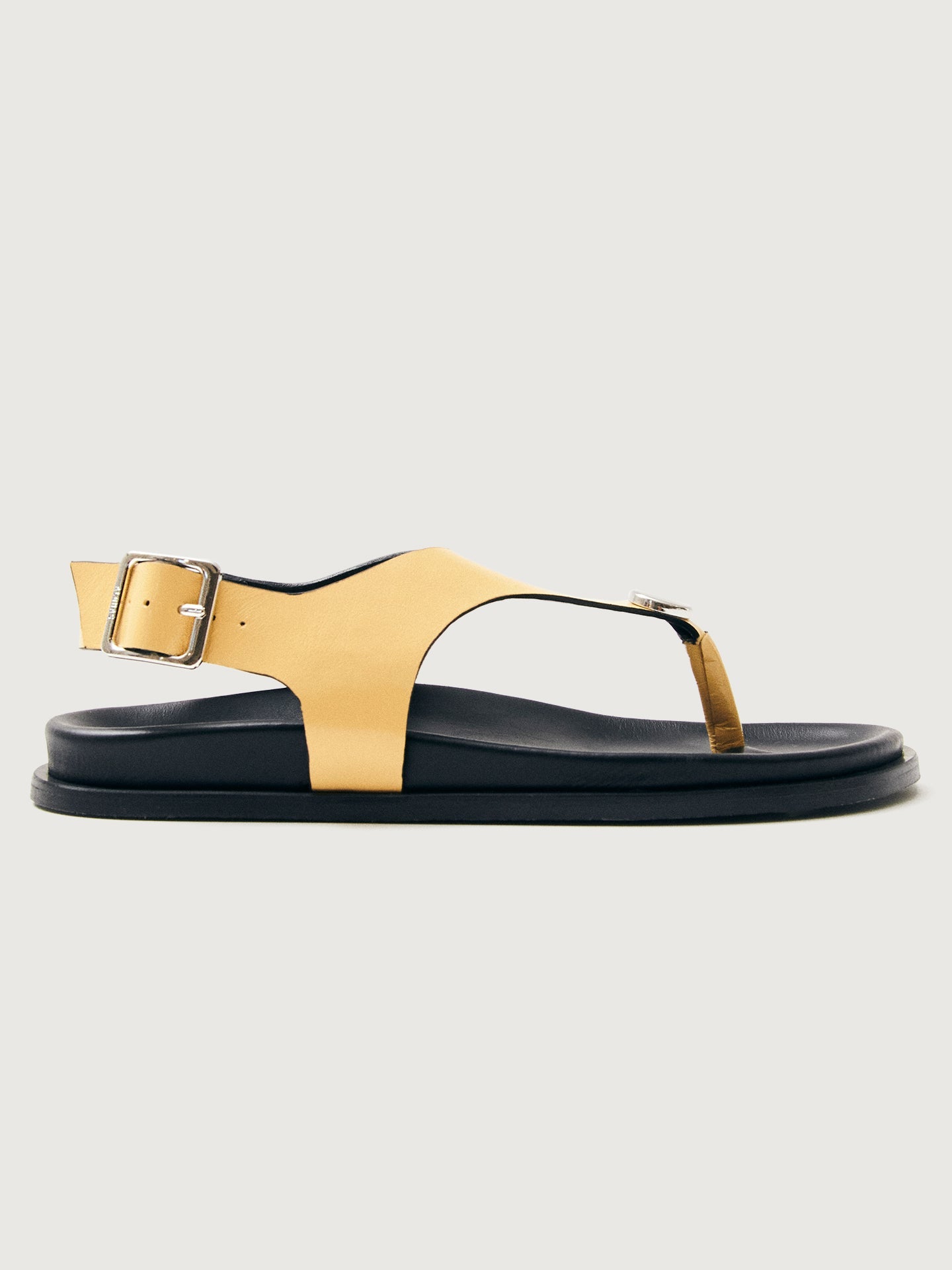 Buttery yellow colored sandal with black sole and silver hardware. 