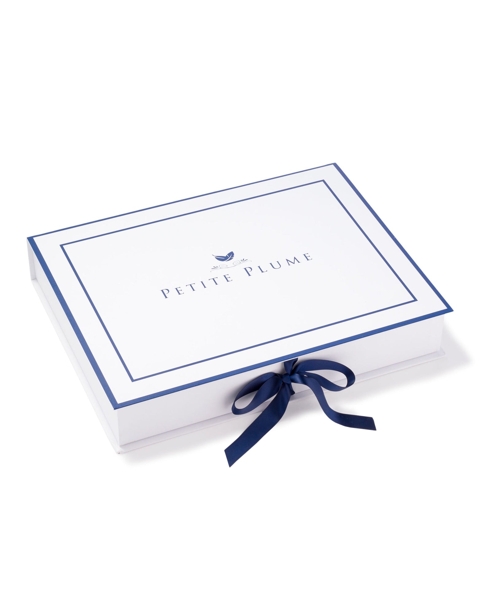 A white rectangular box, blue-edged, displays Petite Plume with a bird graphic above. Tied with a dark blue ribbon, it echoes the elegance of Womens Gauze Willow Scoopneck Top in Pink from Petite Plumes luxury Gauze Collection.