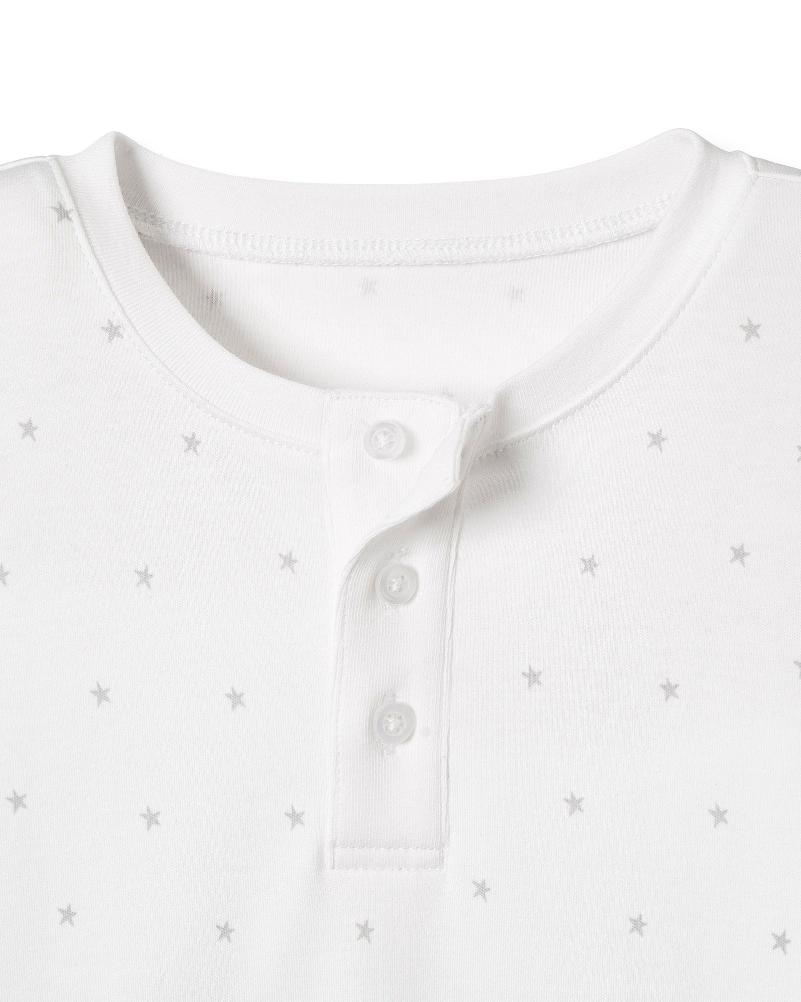 Close-up of a Kids Pima Snug Fit Pajama Short Set in Grey Stars by Petite Plume showcasing a white henley shirt with a round neckline and three-button placket, featuring a subtle grey star pattern, perfect for an effortlessly coordinated sleepwear style.