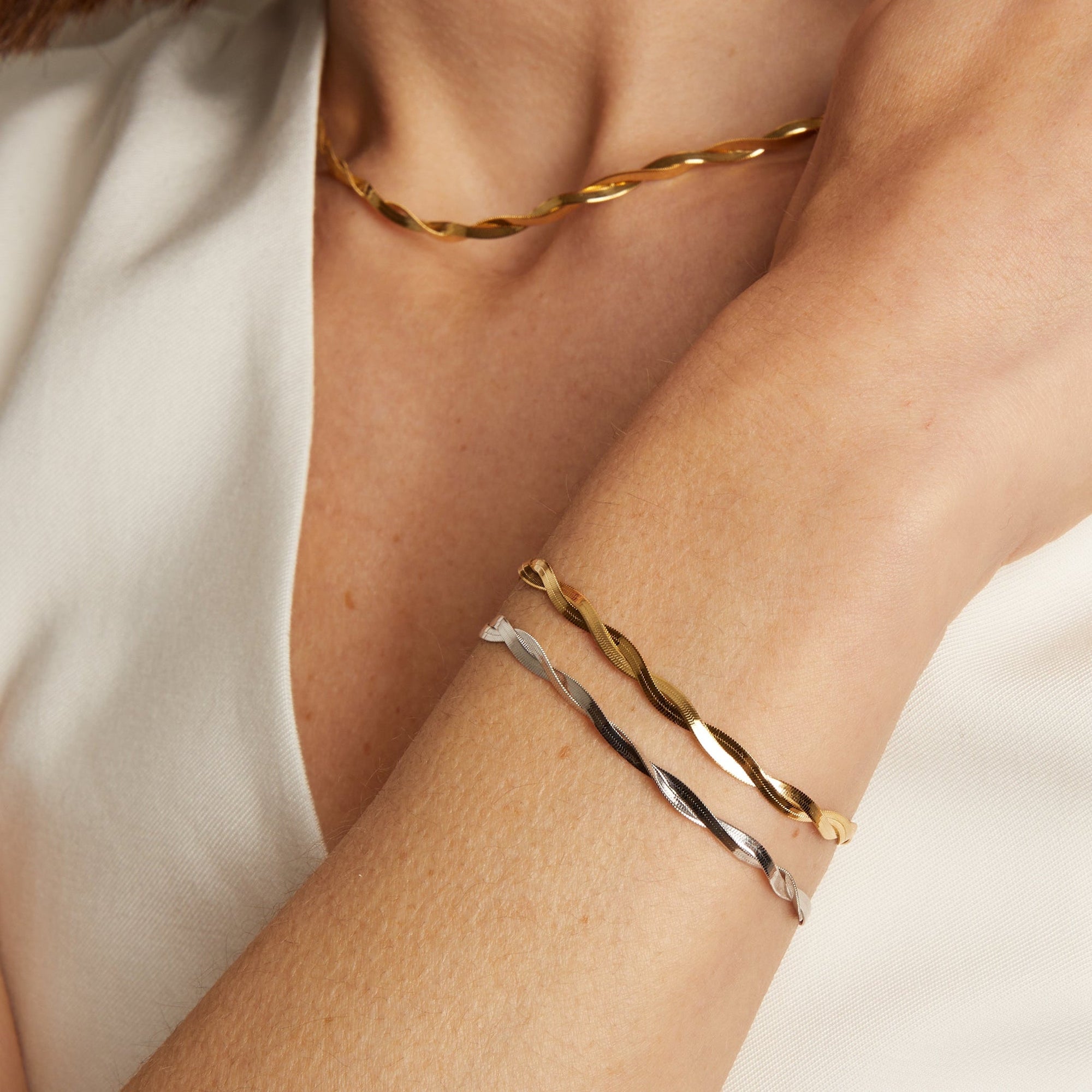 Model. A person wearing a yellow gold herringbone twist bracelet on their wrist.
