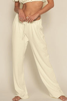 Cream ribbed drawstring pants with relaxed wide-leg fit shown on model.