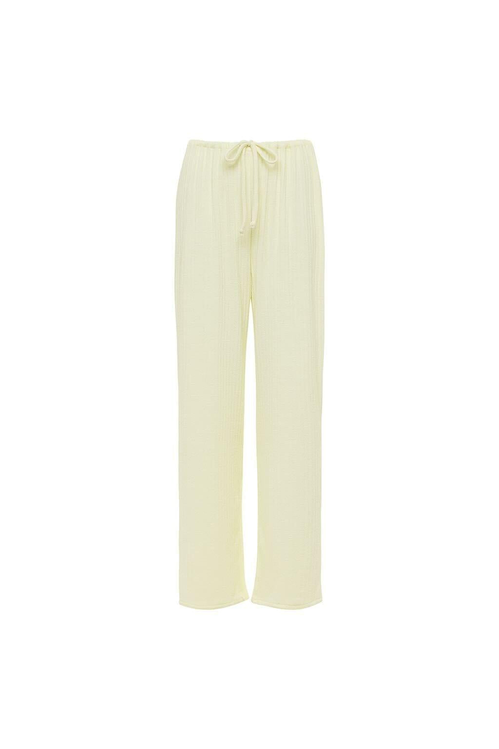 Cream-colored ribbed pants with drawstring waistband and straight leg silhouette.