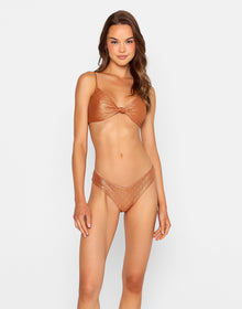 Model wearing the 'Bethany Tango Bottom - Gold Diamond,' a shimmering V-cut bikini bottom with a metallic diamond-textured finish in a rich copper-gold hue. This cheeky, figure-flattering swim bottom offers a glam, high-leg silhouette—perfect for sun-soaked getaways and luxe poolside looks.