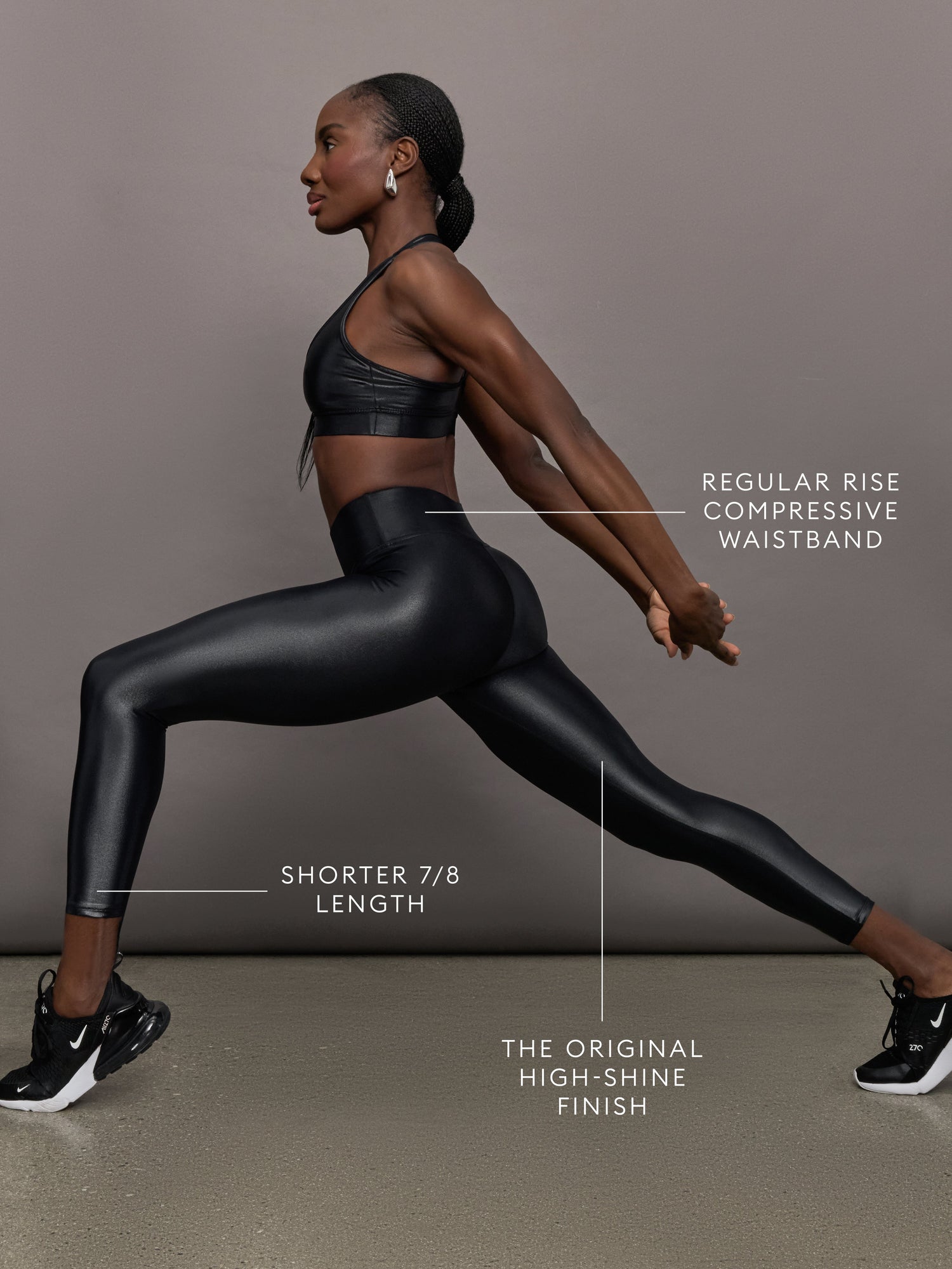 Model wears a mid rise waisted pair of liquidy shine black leggings that hit at model's mid to low calf.