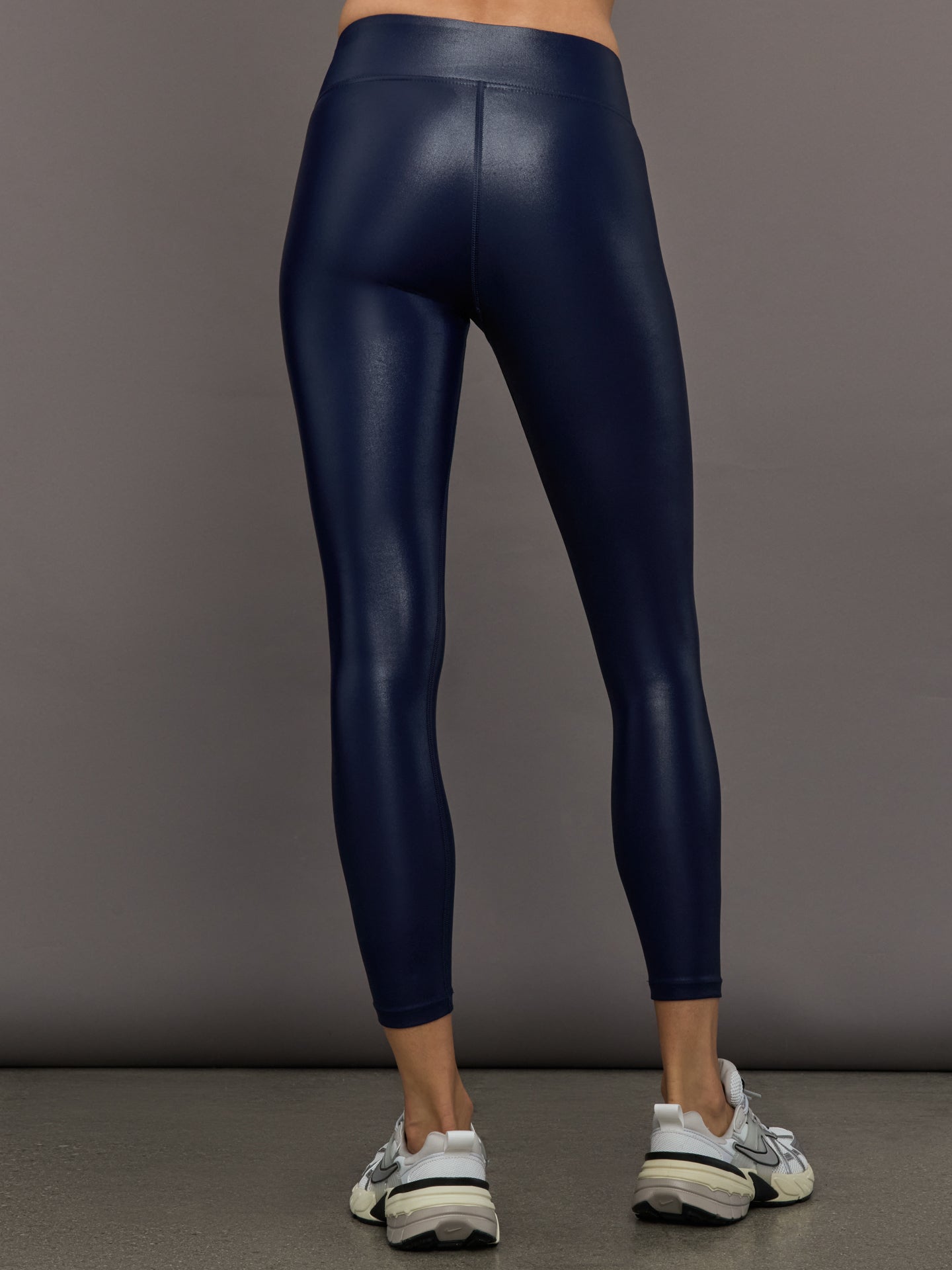 Model wears liquid takara shine leggings in regular rise with a thick waistband in navy.