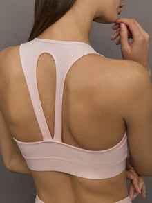 Model wears a v neck baby pink bra in a liquidy takara shine finish. 