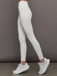 Model wears a highly compressive white high waisted legging. 