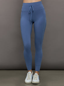 Model wears a periwinkle blue buttery soft pair of leggings with pockets and drawstring waist, perfect for all activities. 