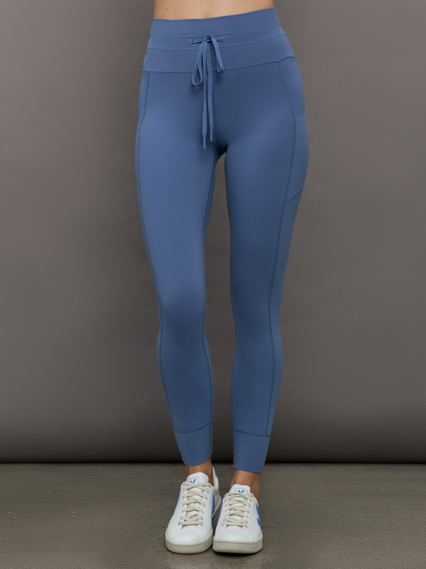 Model wears a periwinkle blue buttery soft pair of leggings with pockets and drawstring waist, perfect for all activities. 