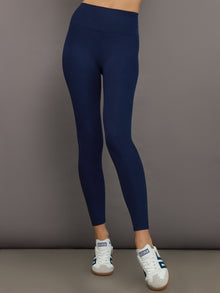 Model wears navy, high-rise leggings with a ribbed texture and a smooth, form-fitting silhouette.
