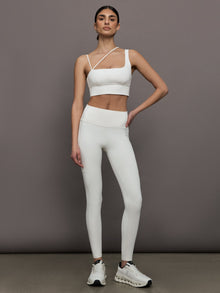 Full outfit view of the Asymmetrical Strappy Bra in Diamond Compression Cloud Dancer with matching leggings and sneakers.