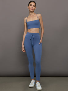 Model wears a periwinkle blue buttery soft pair of leggings with pockets and drawstring waist, perfect for all activities. 