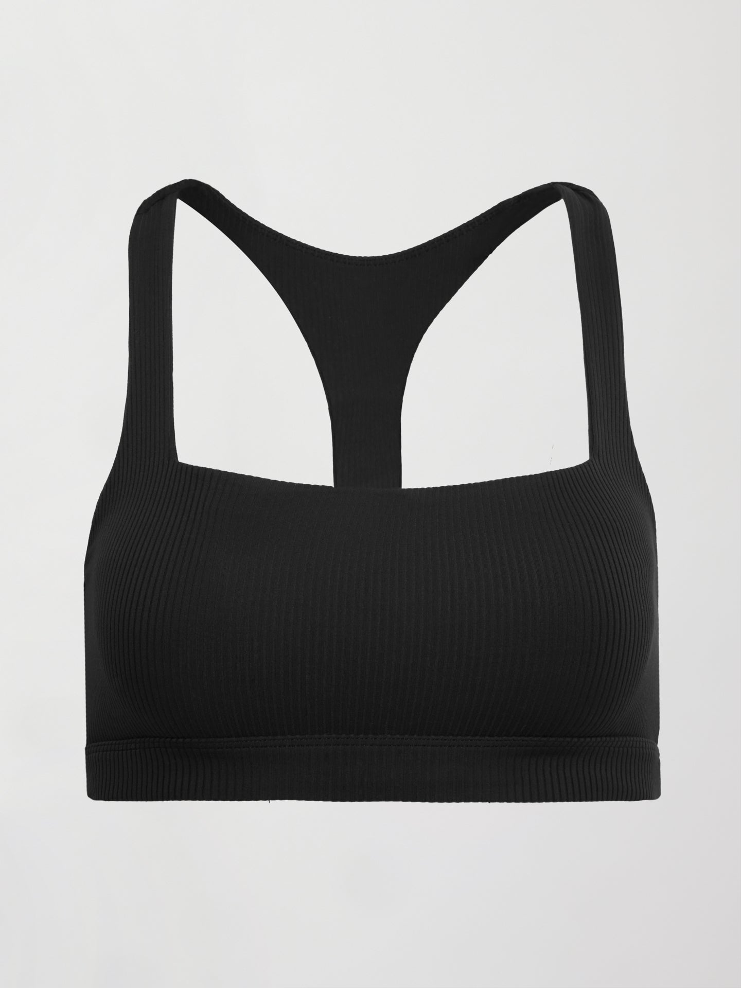 Model wears a black, ribbed, racerback sports bra with a smooth, sculpting fit.
