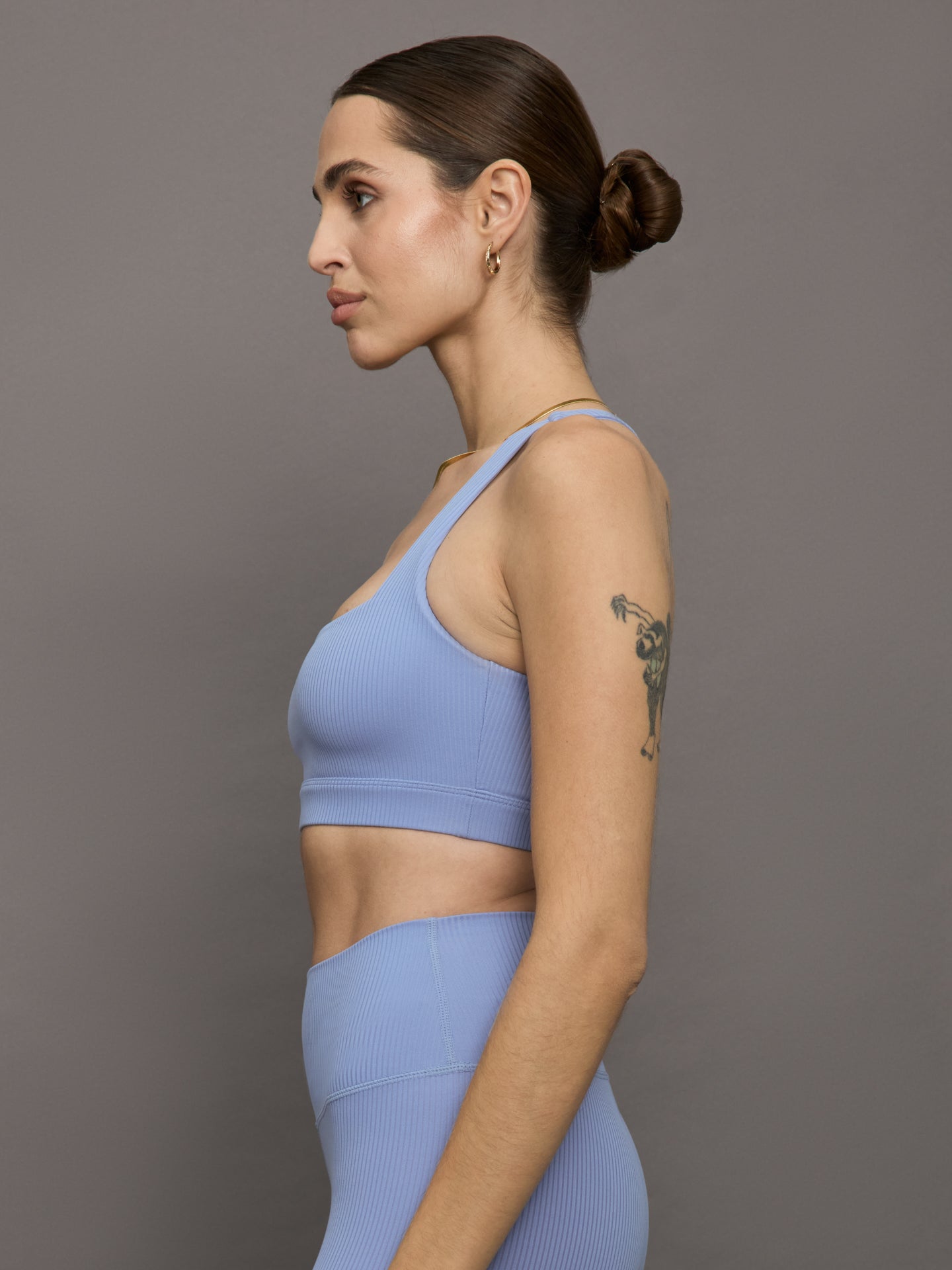 Model wears a periwinkle colored ribbed square neck sports bra with racerback detail. 